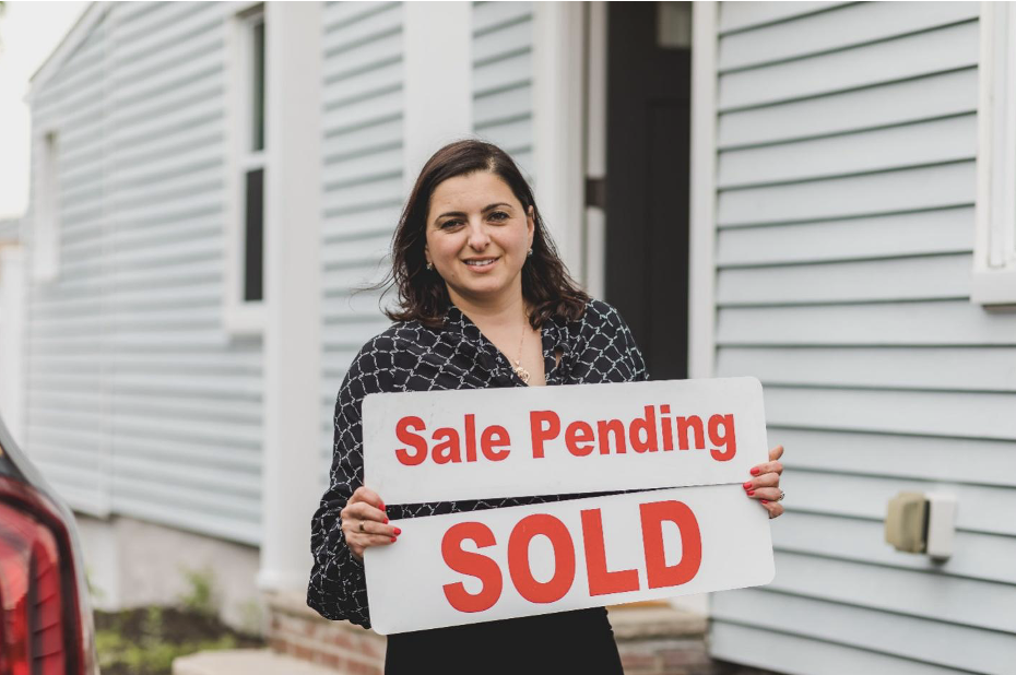 Realtor Holding a ‘Sale Pending’ Sign