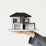 Realtor Holding a Miniature House