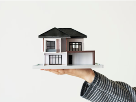 Realtor Holding a Miniature House