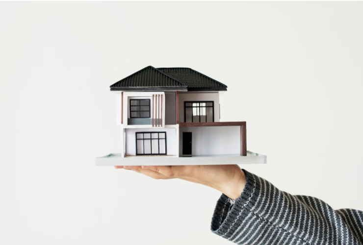 Realtor Holding a Miniature House